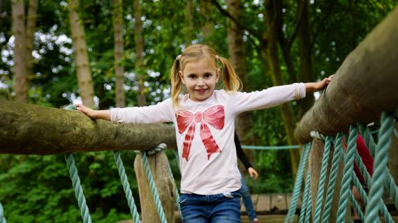 Pige leger på tarzanbanen i Madsby Legepark